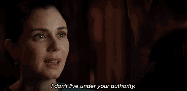 a woman says " i don t live under your authority " in a dark room