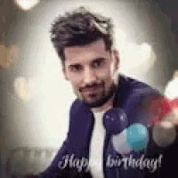 a man in a suit and tie is holding balloons and smiling .