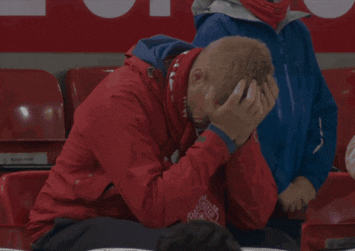 a man in a red jacket with manchester united on it