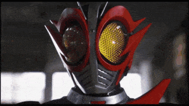 a close up of a masked superhero 's face with a yellow eye