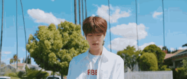a young man wearing a white shirt with the word fbi written on it