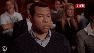 a group of people are sitting in a room with a red sign that says live