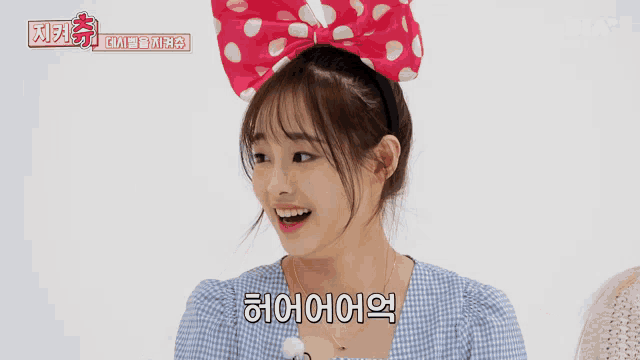 a girl wearing a headband with mickey mouse ears is smiling and says 하이어어어