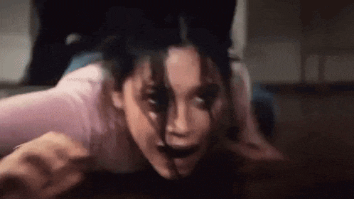 a close up of a woman with blood on her face in a room .