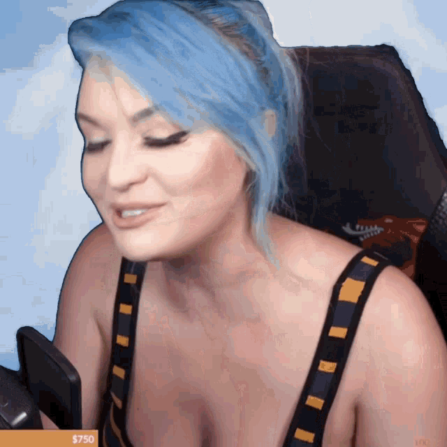 a woman with blue hair is sitting in a chair with a sign that says $ 750 on the bottom