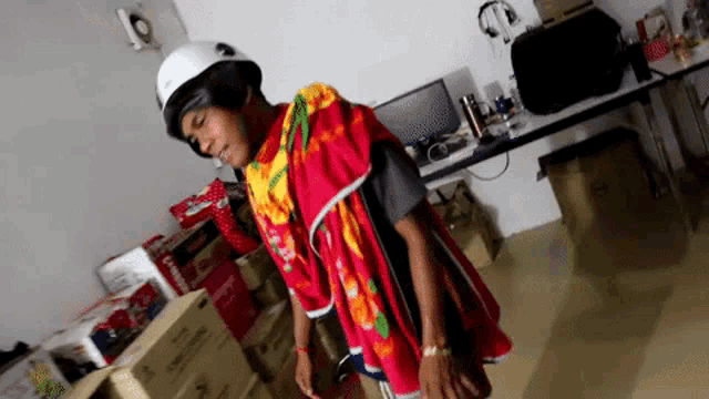 a man wearing a white helmet and a colorful shirt stands in a room