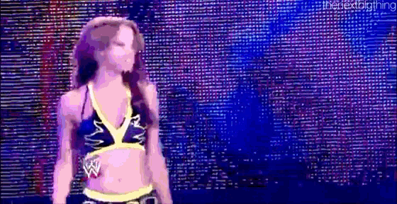 a woman in a bikini is standing on a stage in front of a screen .
