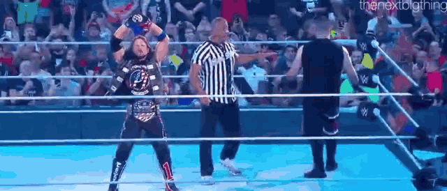 a wrestling match is being held in a ring with a referee .