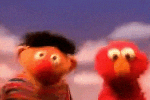 elmo and ernie are standing next to each other in a blurry photo