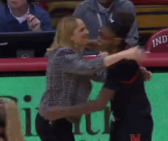 a woman hugging a man in front of a sign that says ind on it