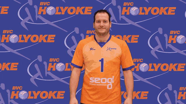 a man stands in front of a holyoke banner
