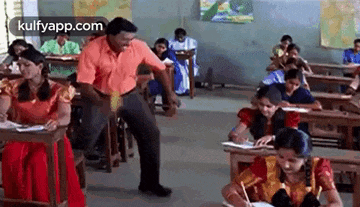 a man is dancing in a classroom while students sit at desks .