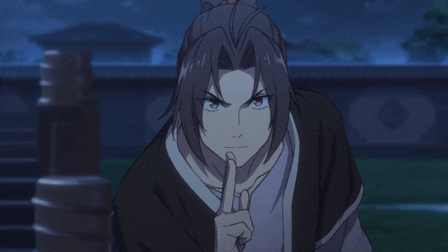 a man with a ponytail has his finger on his mouth