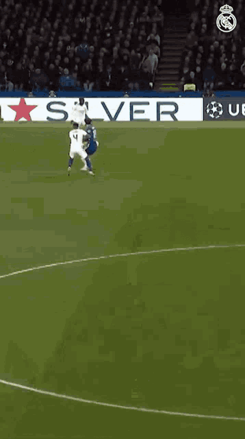a soccer game is being played on a field with a star advertised on the sidelines .