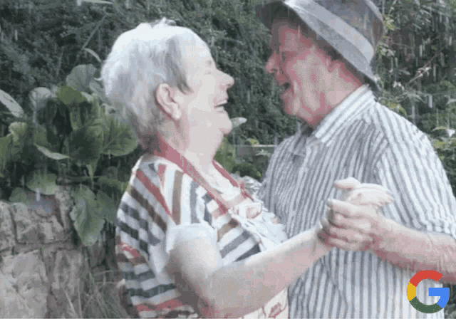 a man and woman are dancing with a google logo behind them