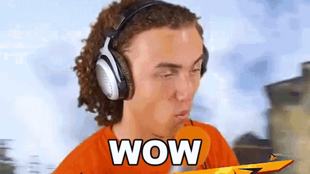 a man wearing headphones and an orange shirt says wow