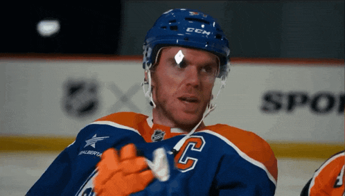 a hockey player wearing a blue helmet with ccm on it