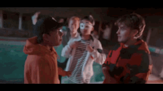 a group of young people are standing next to each other in front of a swimming pool .