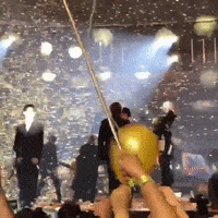 a group of people holding balloons in front of a crowd