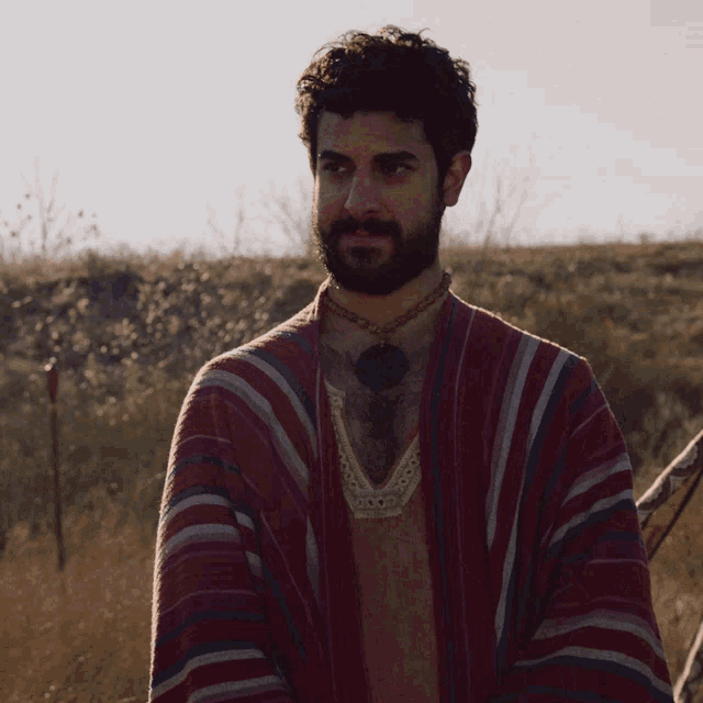 a man with a beard is wearing a red striped shirt