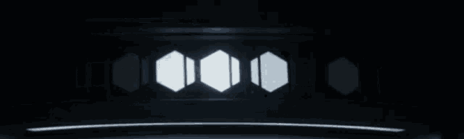 a dark room with a lot of windows and a light coming out of them