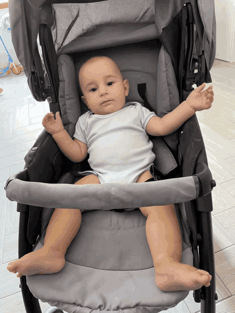 a baby is sitting in a gray stroller