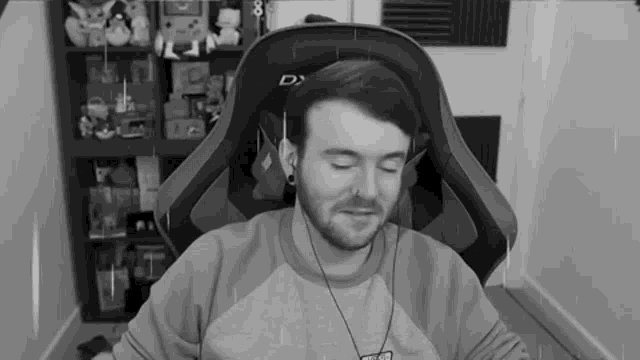 a black and white photo of a man in a gaming chair