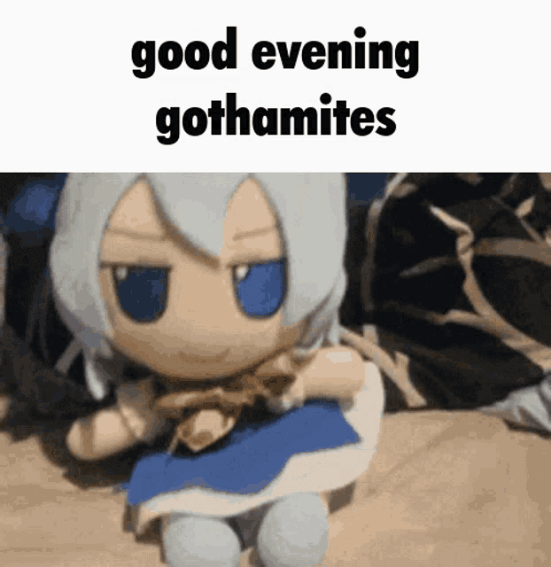a stuffed doll is sitting on a bed with the words " good evening gothamites " above it