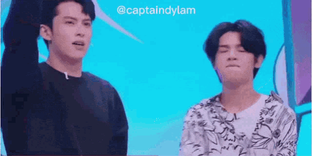 a couple of men standing next to each other on a stage .