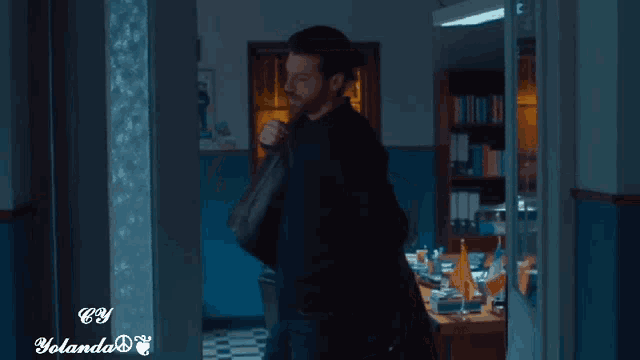 a man walking through a hallway with a watermark that says cy yolanda