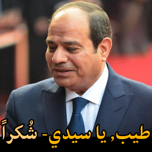 a man in a suit and tie is smiling with arabic writing above him