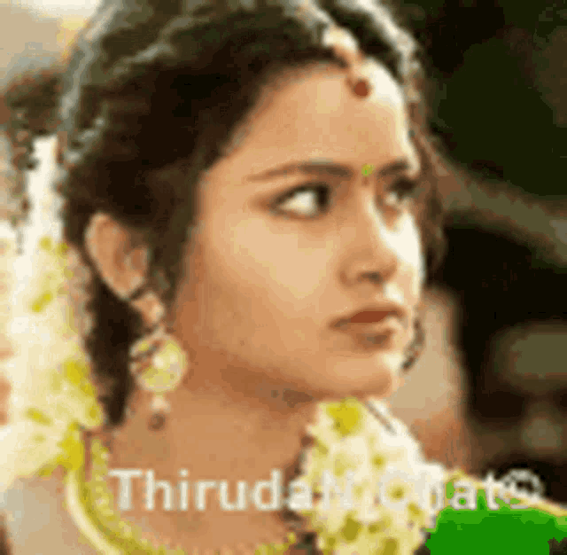 a close up of a woman 's face with flowers in her hair and a green shirt .