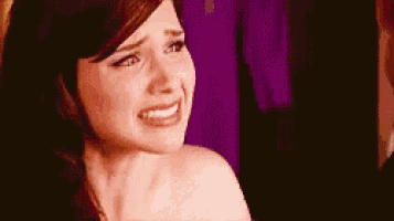 a woman is crying and smiling while making a funny face .