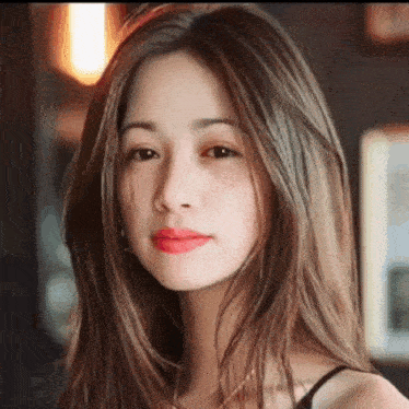 a close up of a woman 's face with long hair and red lipstick