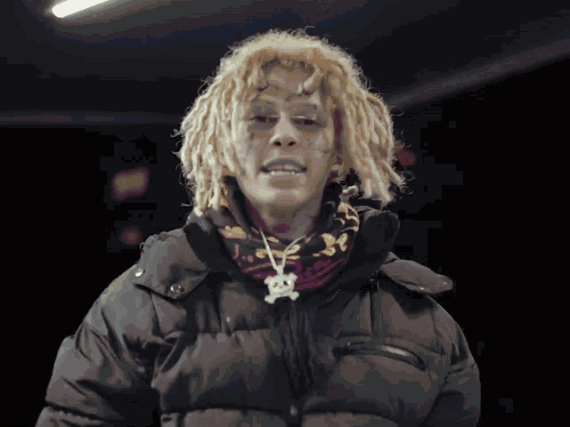a man with dreadlocks and a skull necklace