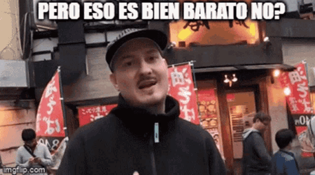 a man wearing a hat is standing in front of a restaurant with a sign that says pero eso es bien barato no