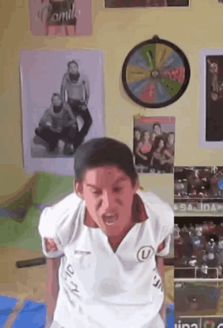 a boy wearing a white shirt with the letter u on the front