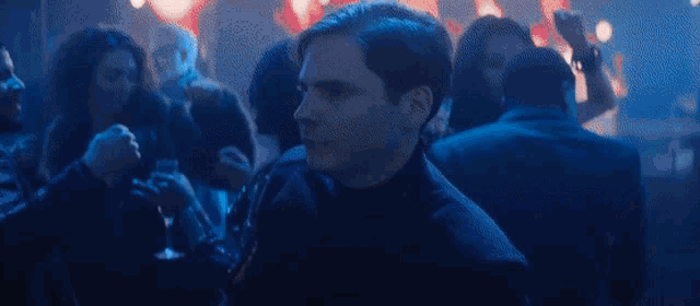 a man is dancing in a crowd of people at a party in a club .