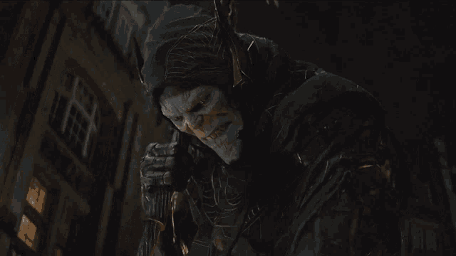 a man in a hooded costume is holding a sword in his hand
