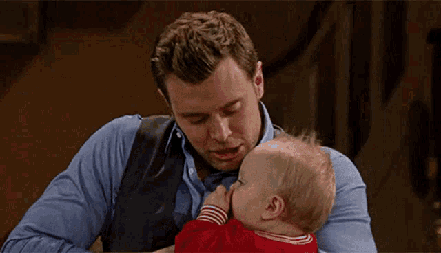 a man kisses a baby on the cheek