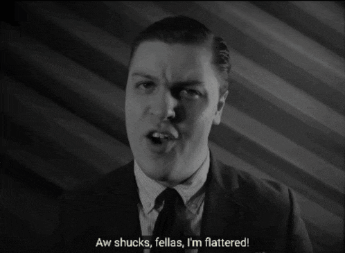 a man in a suit and tie says " i think " in a black and white photo