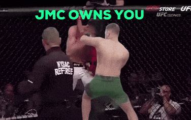 a man in a nysac referee 's shirt watches two men fight in a ring