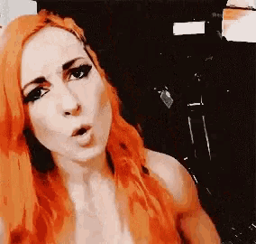 a woman with red hair is making a funny face while looking at the camera .