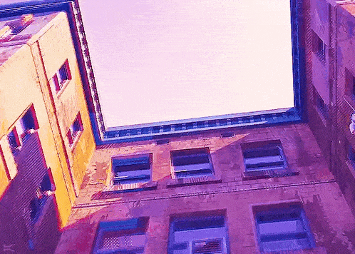looking up at the top of a building with a purple sky behind it
