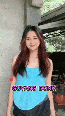 a woman in a blue tank top with the words goyang donk on the bottom