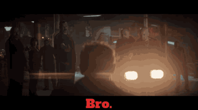 a group of men are standing in a dark room with the word bro on the bottom right