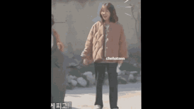 a woman in a brown jacket and black pants is dancing on a street .