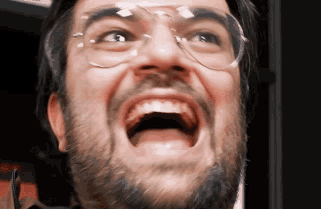 a man with glasses and a beard is making a face