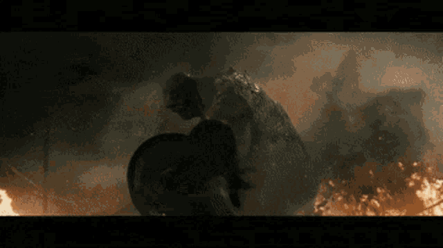 a man in a black shirt is standing in front of a large monster