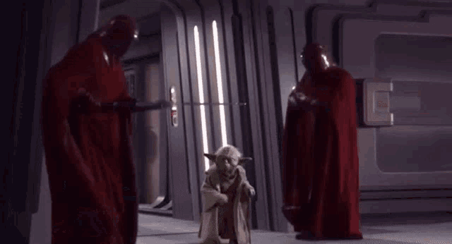 a statue of yoda is standing in a hallway next to a group of soldiers .